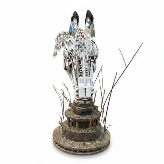 A rustic metal sculpture of a horse head mounted on a circular base.