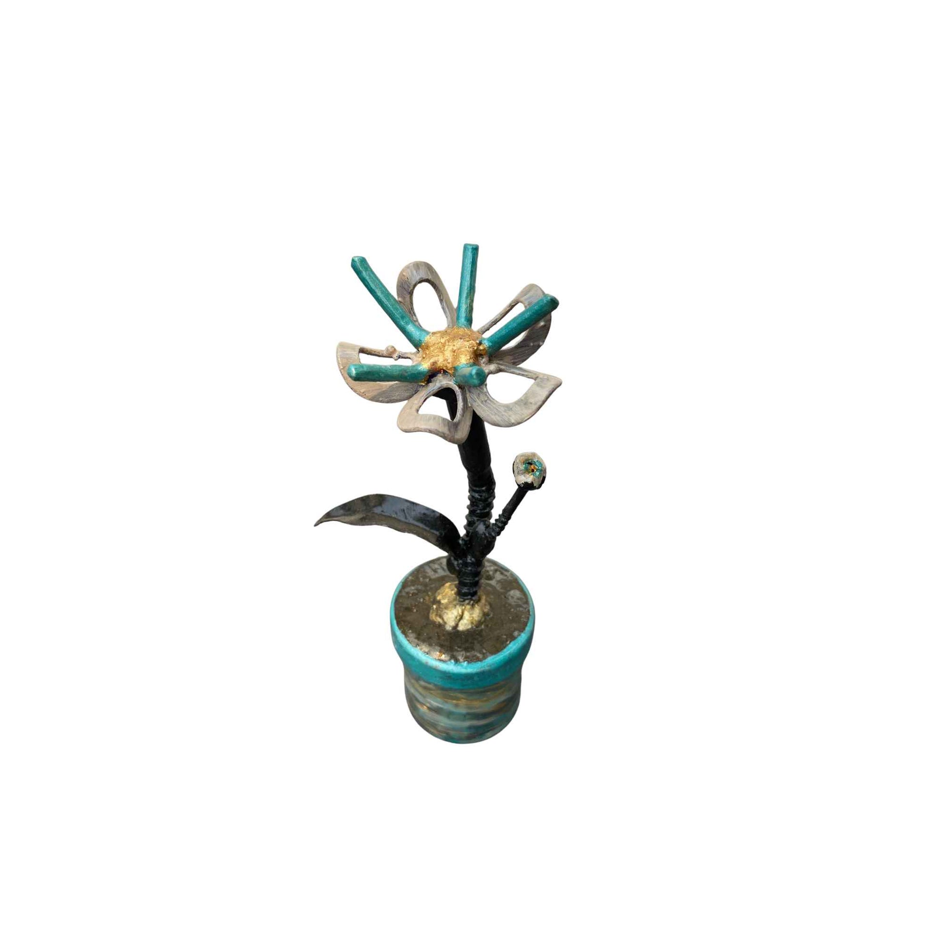 A decorative metal flower sculpture with turquoise, gold, and silver elements, set against a plain white background.