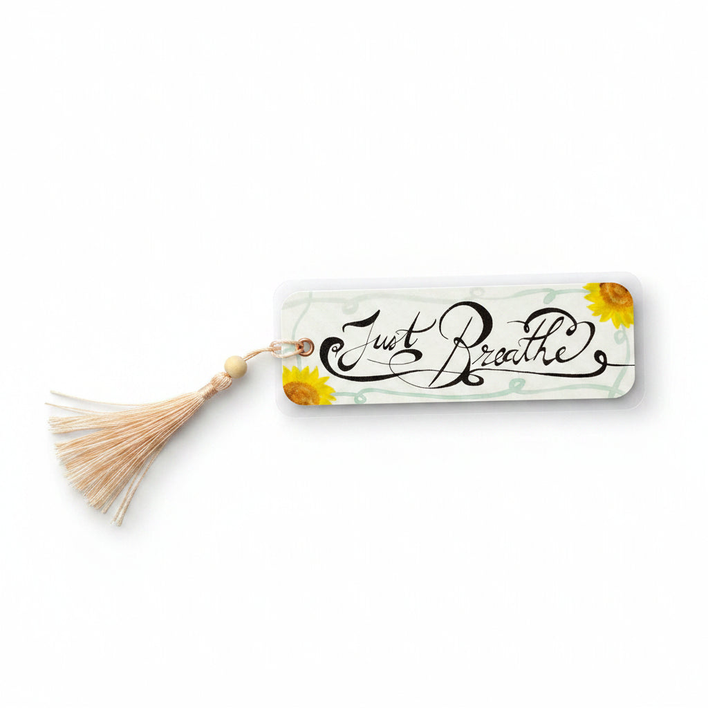 A rectangular watercolor laminated bookmark with a beige tassel and wooden bead, featuring the cursive text 'Just Beautiful' in black with yellow sunflower illustrations.