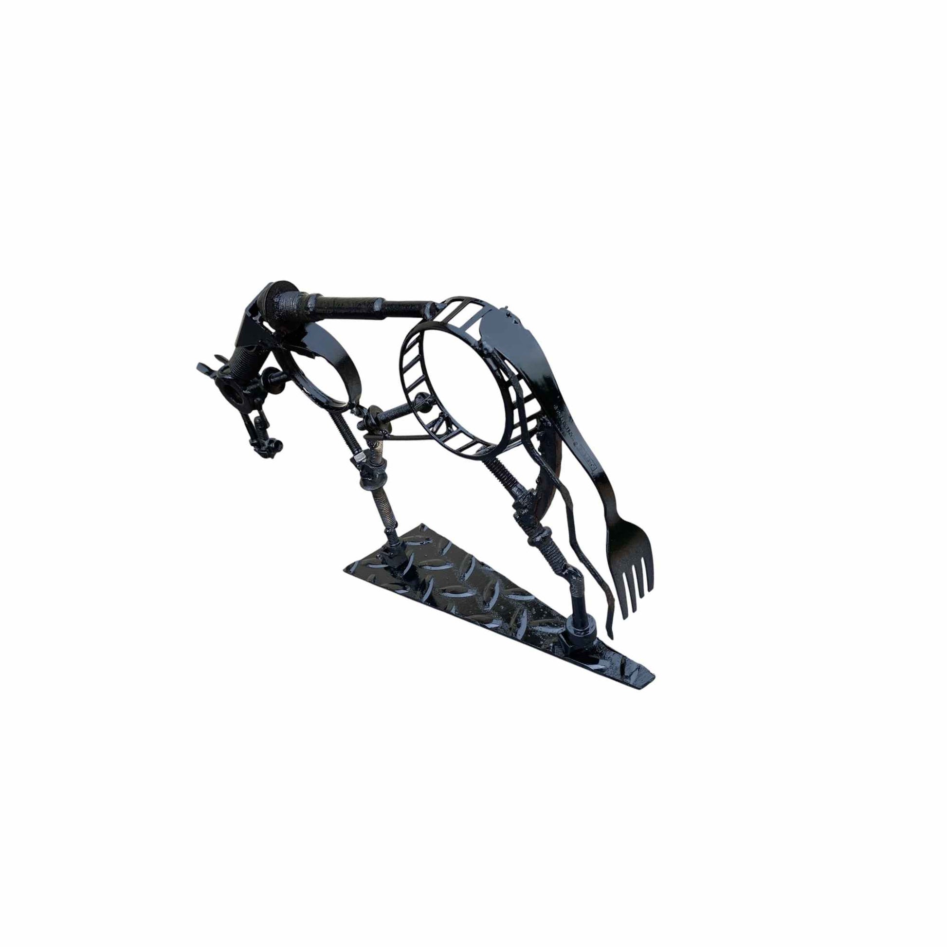A black metal horse sculpture with a fork on its tail, standing on a diamond-plate style base against a plain white background.