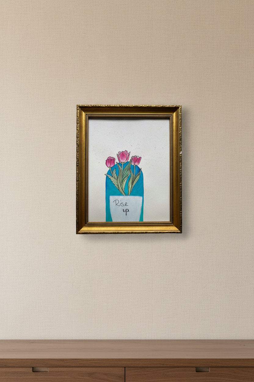 A framed art print featuring a white vase with pink tulips and the handwritten text 'Rise up' with a boho teal background, enclosed in an ornate gold frame.